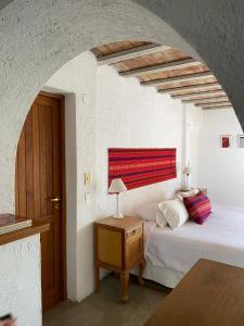 1 dormitorio con 1 cama y 1 mesa con lámpara en Casona Medrano en Luján de Cuyo