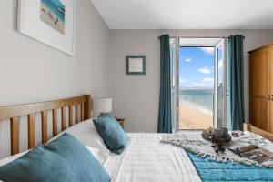a bedroom with a bed with a view of the beach at 11 At The Beach in Beesands