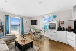 a kitchen and living room with a view of the ocean at 11 At The Beach in Beesands