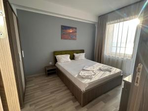 een kleine slaapkamer met een bed en een raam bij Maria Summer Apartaments in Mamaia
