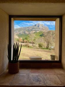 uma janela com vista para uma montanha em Maison à Aix en provence au pied de la Sainte Victoire em Beaurecueil