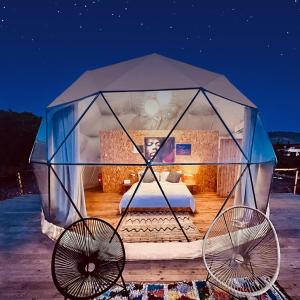 a bed in a dome tent with two fans at Sweet Dome Tafedna in Tafedna