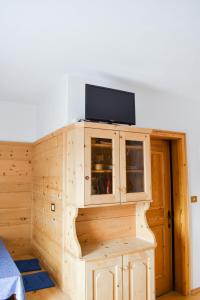 un armario de madera con TV encima. en Apartement Noggler Zimmer mit Frühstück, en Malles Venosta