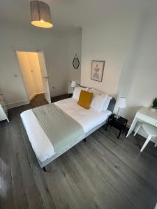 a bedroom with a large white bed and a desk at Corner Stone House - Apartment 2 in Great Yarmouth