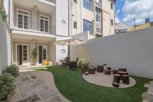 - une terrasse avec une table et un parasol dans la cour dans l'établissement Charm Luxury House, à Porto
