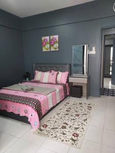 een slaapkamer met een roze bed en een tapijt bij Hanis Homestay De Bangi in Kajang