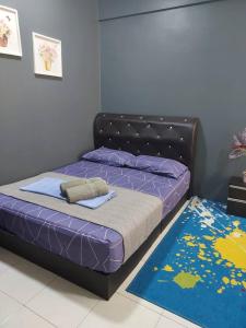 - une chambre avec un lit doté de draps violets et d'un tapis dans l'établissement Hanis Homestay De Bangi, à Kajang