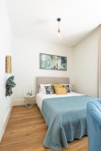 - une chambre avec un lit et un canapé bleu dans l'établissement Charm Luxury House, à Porto