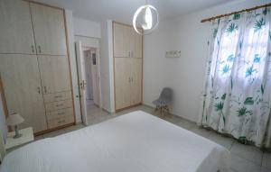 a bedroom with a white bed and a window at Lavender Home in Sifnos