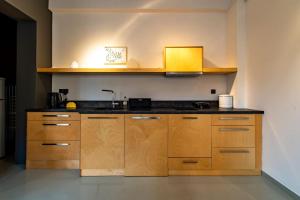 a kitchen with wooden cabinets and a sink at Artistic Spacious Studio Apartment next to metro Monastiraki in Athens