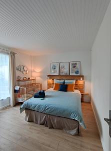 a bedroom with a large bed with blue and orange pillows at Atelier des sens 89 in Évry