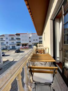 a balcony with a wooden table and chairs at Spray B&B Sitio in Nazare, European style in Nazaré