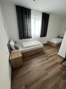 um quarto com 2 camas e piso em madeira em Boardinghouse MDS em Aschheim