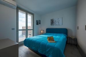 a bedroom with a blue bed and a large window at Donatello in Parzanica