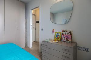 - une chambre avec un lit bleu et un miroir dans l'établissement Donatello, à Parzanica