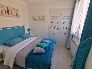 a bedroom with a bed with blue sheets and pillows at location Coma Chéric et parking in Collioure