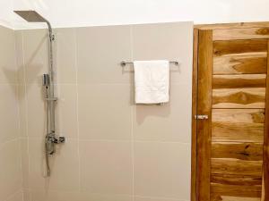 baño con cabina de ducha y toalla blanca en Villa River Edge, en Weligama