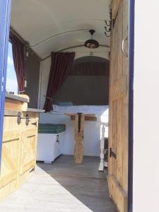 een open deur van een camper met een tafel erin bij Pipowagen Eldikse Blauwe in Lienden