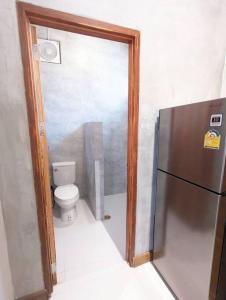 a small bathroom with a refrigerator and a toilet at Maison moderne proche du centre-ville in Luang Prabang