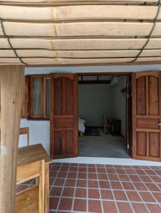a room with wooden doors and a room with a floor at Maison moderne proche du centre-ville in Luang Prabang