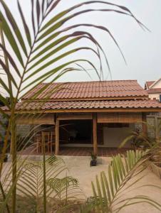 a building with a red roof with a patio at Maison moderne proche du centre-ville in Luang Prabang