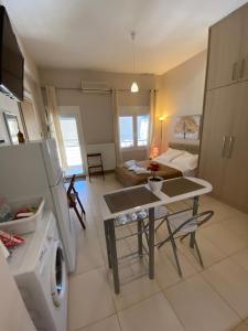 a kitchen and living room with a table and a washing machine at BLUE PHAISTOS APARTMENTS No1 in Moírai