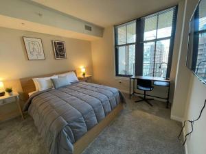 a bedroom with a bed and a desk and windows at Beautiful 1 Bedroom Apartment at Pentagon City in Arlington