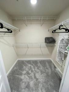 a walkin closet with white walls and white shelves at Beautiful 1 Bedroom Apartment at Pentagon City in Arlington