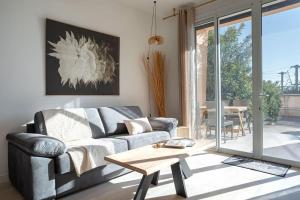 salon z kanapą i stołem w obiekcie Duplex Mandelieu by Halldis w mieście Mandelieu-la-Napoule