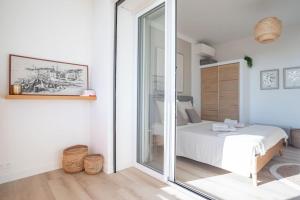 - une chambre avec un lit et une porte coulissante en verre dans l'établissement Duplex Mandelieu, à Mandelieu-la-Napoule