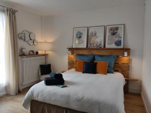 een slaapkamer met een groot bed met blauwe en oranje kussens bij Atelier des sens 89 in Évry