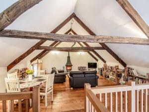 a living room with a table and chairs and a library at The Milking Parlour in Beaworthy