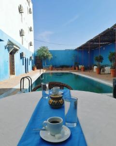 una mesa con una taza de café sobre un mantel azul en Riad Freija-TAROUDANT en Sidi Abd el Kader