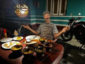 a man sitting at a table with bowls of food at Mihira Guest House in Ahangama