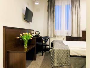 Pokój hotelowy z sypialnią z biurkiem i łóżkiem w obiekcie Hotel Fero Express POKOJE KLIMATYZOWANE AC w Krakowie