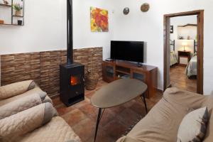 sala de estar con sofá y fogones en Cortijo Salva, en Periana