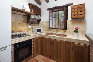 a kitchen with wooden cabinets and a sink at Cortijo Salva in Periana
