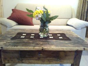 un vase de fleurs sur une table en bois dans l'établissement L'Abete Bianco Casa in montagna, à Vezzano