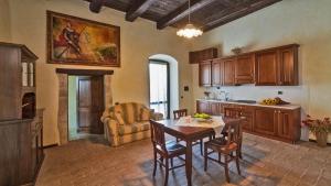 a kitchen and dining room with a table and chairs at Castello di Pupaggi in Sellano