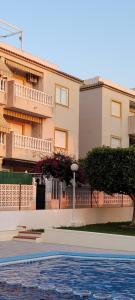 un bâtiment avec une piscine en face d'un bâtiment dans l'établissement Apartamento bajo con terraza y piscina, à Torrevieja