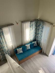 a blue couch in a room with windows at Aleminas Rooms in Symi