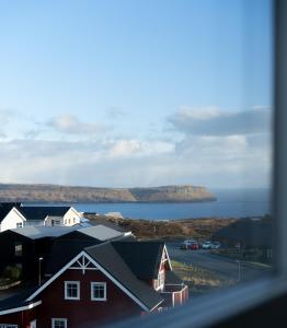 a view of a body of water with houses at New 2 BR Apt - Ocean and Mountain View in Tórshavn