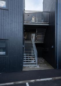 a stairway leading into a building with a railing at New 2 BR Apt - Ocean and Mountain View in Tórshavn
