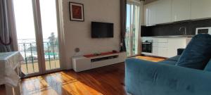 a living room with a blue couch and a television at House Orizzonte - Casa Bianca in Genoa