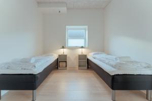 - 2 lits dans une chambre avec fenêtre dans l'établissement New 2 BR Apt - Ocean and Mountain View, à Tórshavn