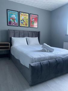 ein großes Bett in einem Schlafzimmer mit drei Bildern an der Wand in der Unterkunft NEW 3-Bedroom Newcastle House in Lemington