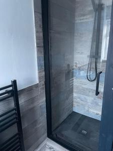 eine Dusche mit einer Glastür neben einer Bank in der Unterkunft NEW 3-Bedroom Newcastle House in Lemington