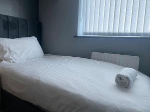 a white bed with a towel on it in a bedroom at NEW 3-Bedroom Newcastle House in Lemington