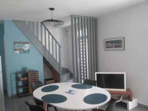 a room with a table with chairs and a staircase at TY PLAGE in Saint-Cast-le-Guildo