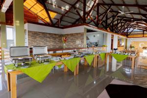 a restaurant with a long table with green tables at Copasu Hotel in Puerto Maldonado
